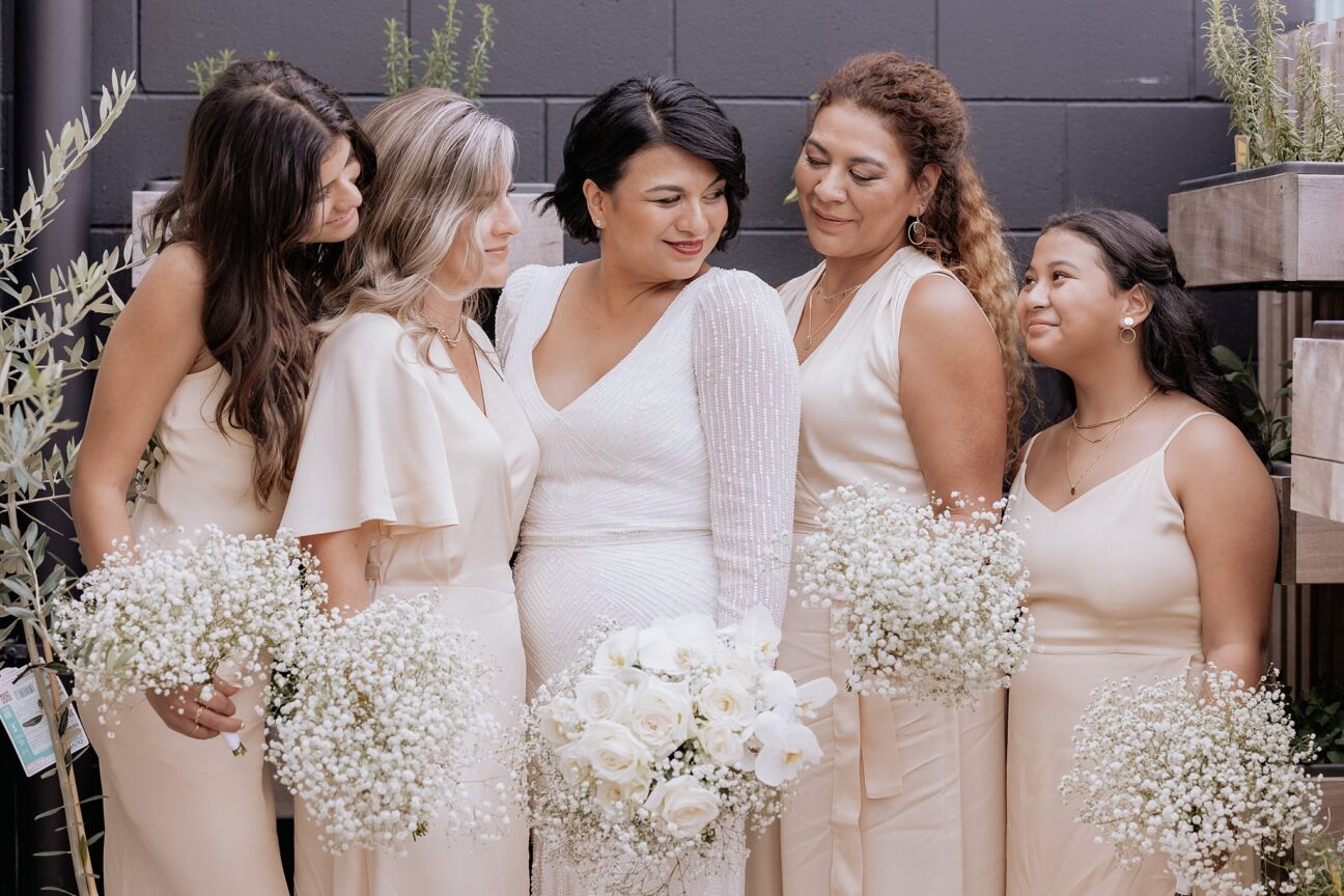 Bride enjoying bridemaids blush pink and gypsophila bouquets