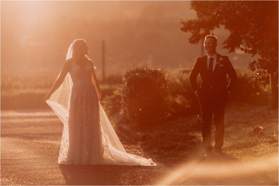Bride looks at husband as golden light hits them
