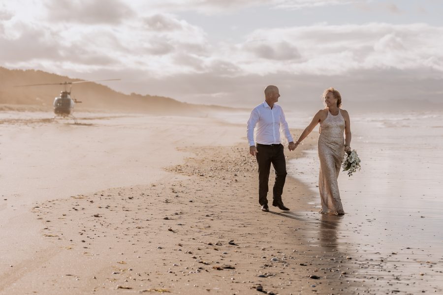 Elopement heli wedding couple walking on beach on Matakana Island Tauranga New Zealand