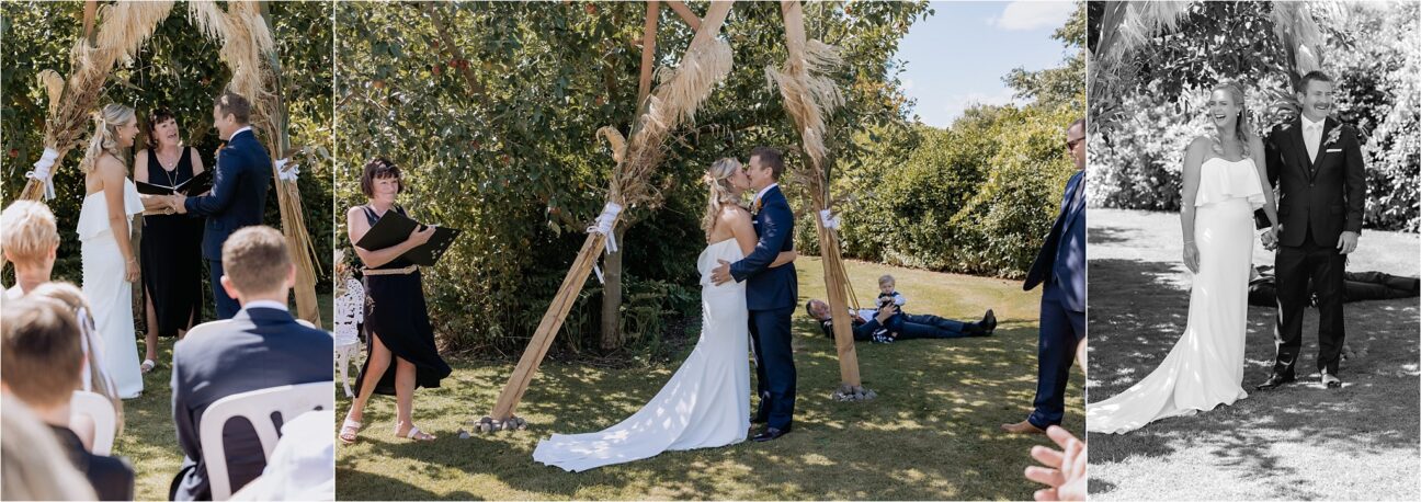 First kiss under the wedding arch back yard Manawatu wedding