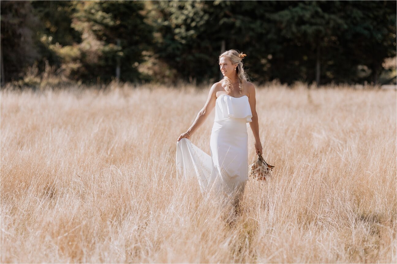 Bride holding train with dried flower bouquet Manawatu back yard wedding in the deer field