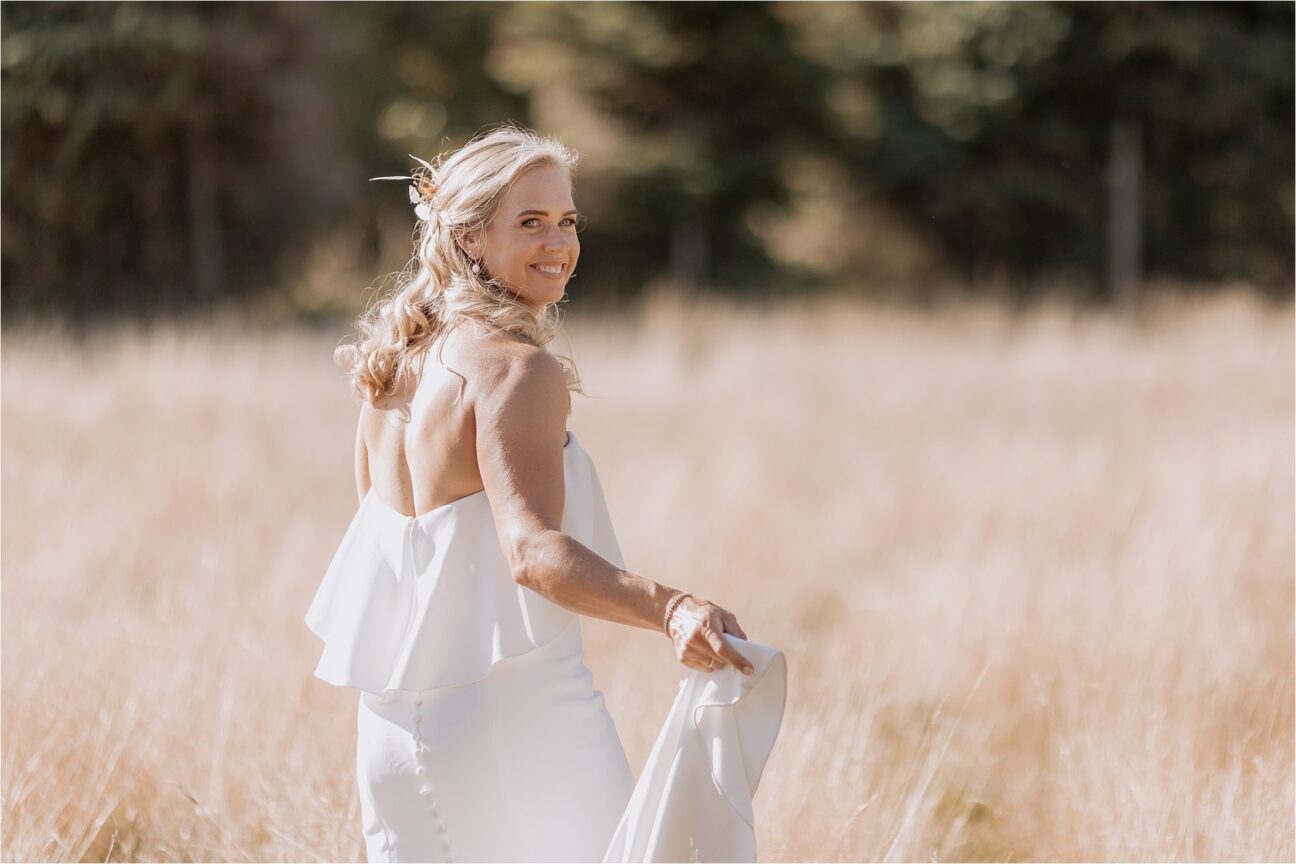 Bride during photos walking away turning to look at camera walking in the deer paddock in Manawatu New Zealand