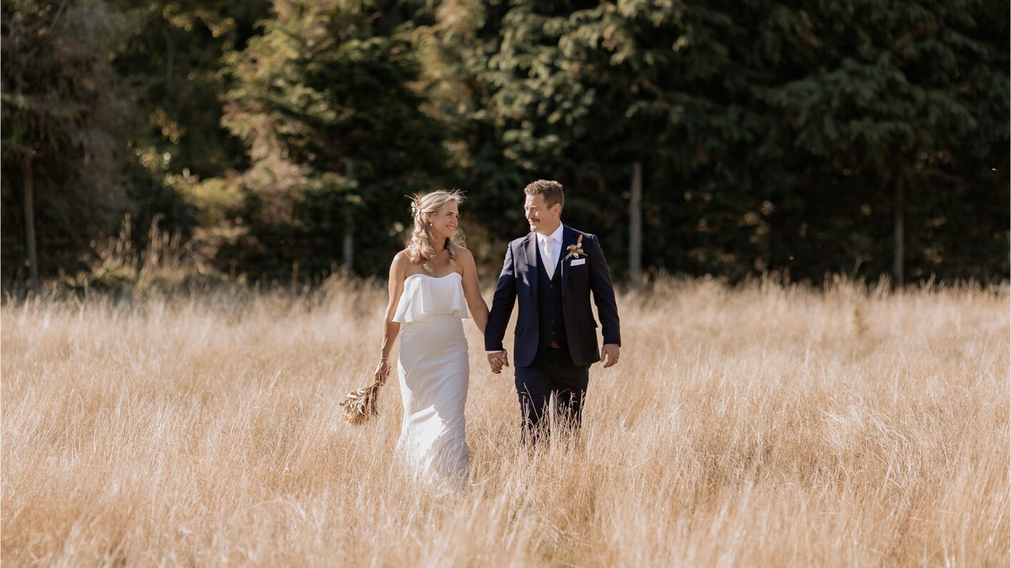 Bride and groom in the deer park in Ohakune walking in the high summer dried grass