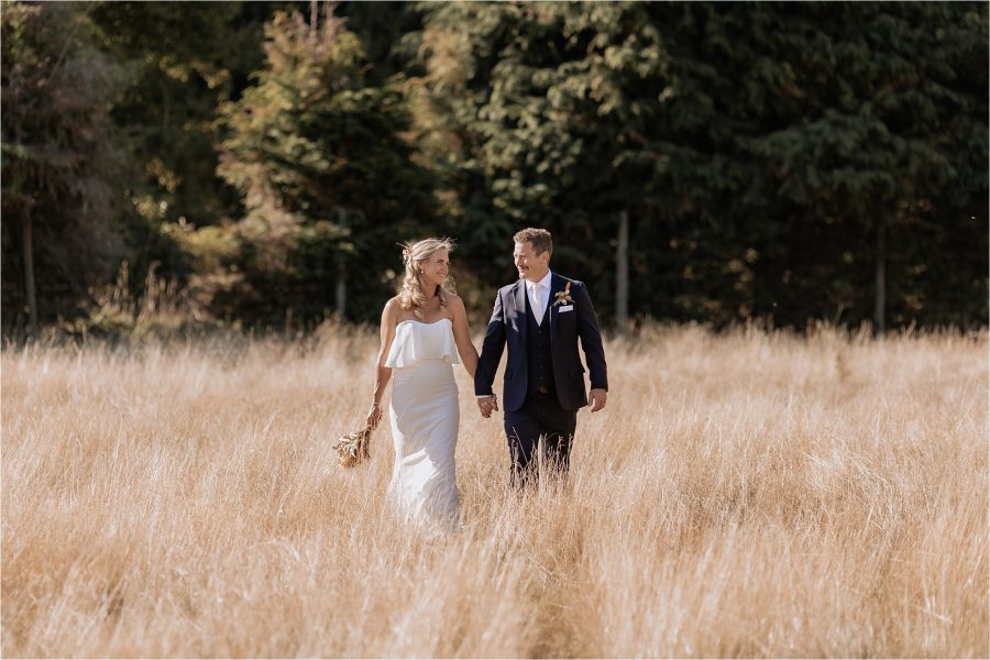 Bride and groom in the deer park in Ohakune walking in the high summer dried grass