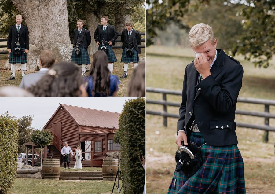 Groom cries as bride comes down aisle with father of the bride at red barn