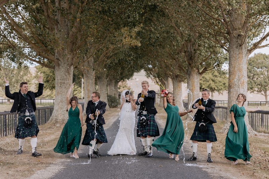 Fun wedding party popping bottle of champagne