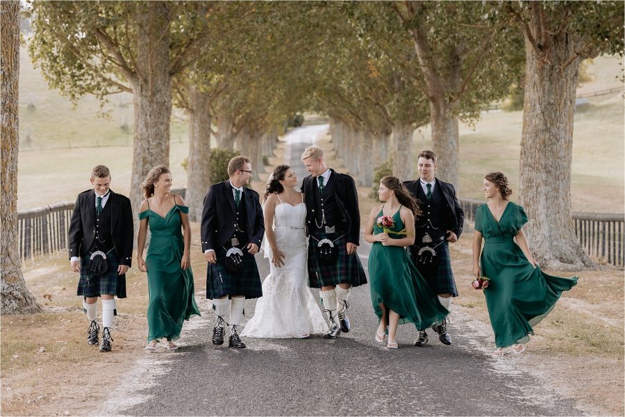 beautiful scottish wedding party walking on red barn driveway