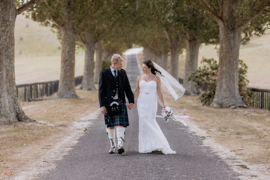 Wedding photos at red barns driveway walking holding hands waikato new zealand
