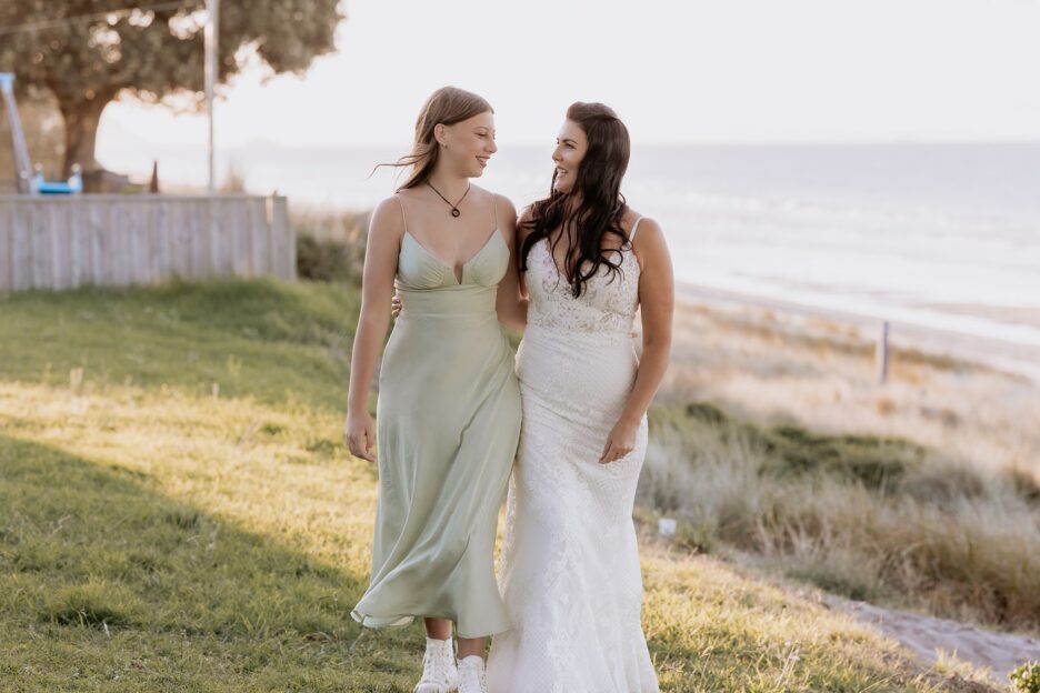 Bridesmaid in pistachio green dress walking with Mum the Bride
