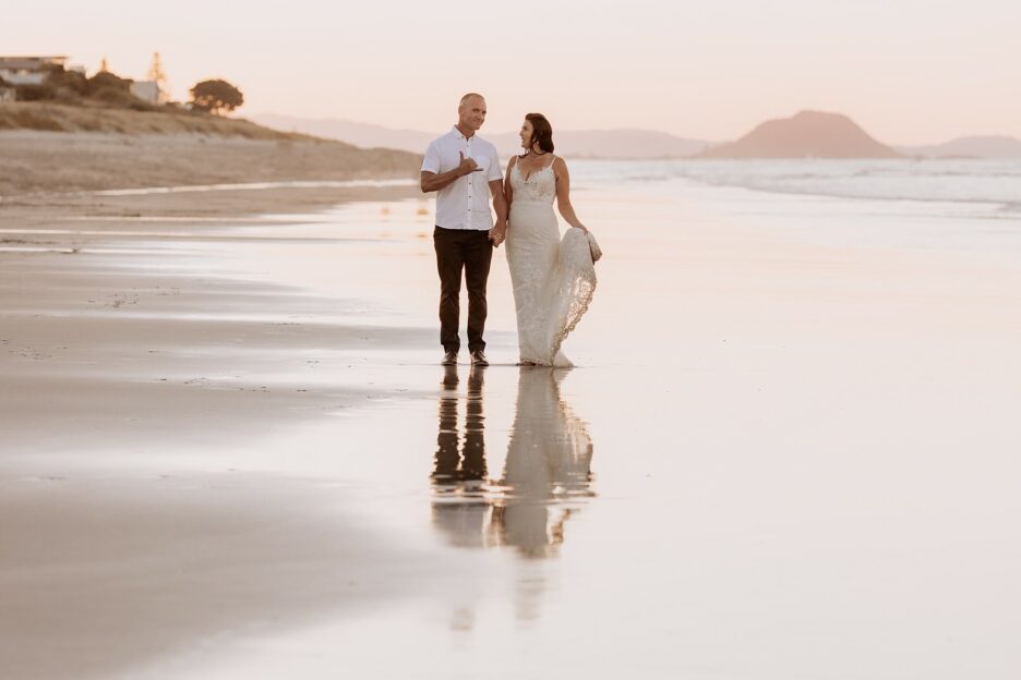 Happy chilled out groom doing thumbs up on beach