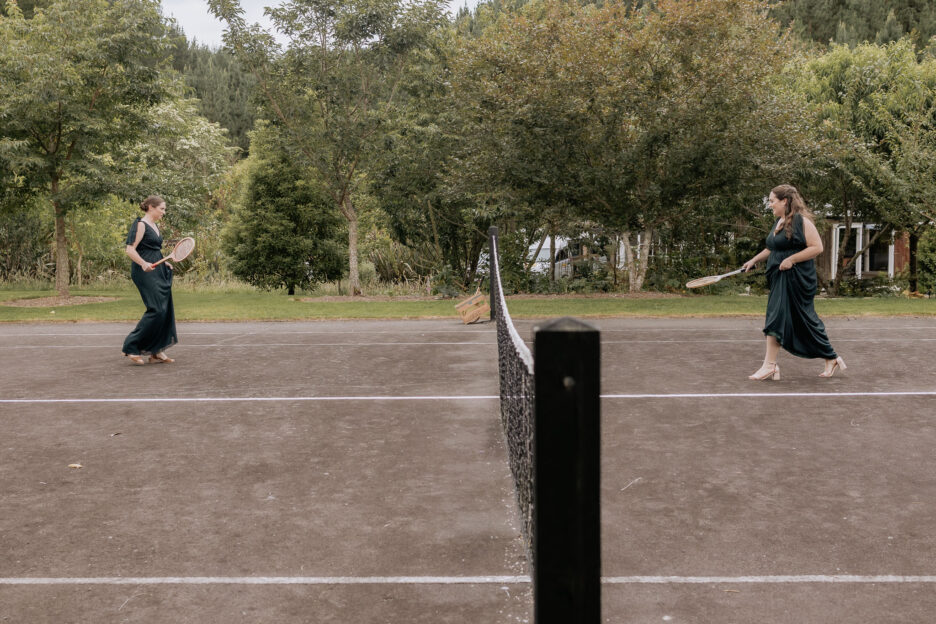 Green bridesmaids playing tennis before wedding ceremony on Old Forest Schools tennis court