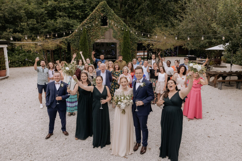Wedding guests celebrating in front of barn at Old Forest School
