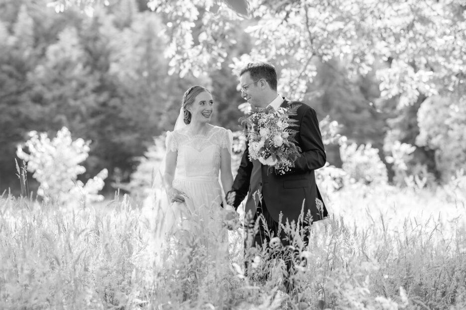 Groom holds brides flowers at Old Forest School during wedding photography