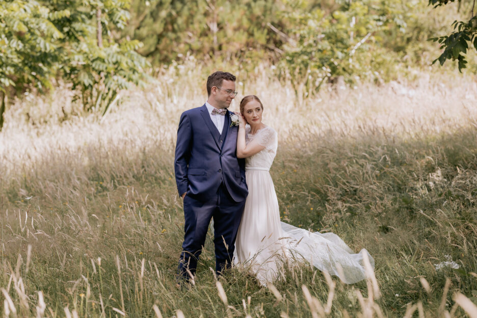 Bride leans on Groom during photos at Old Forest School Te Puke