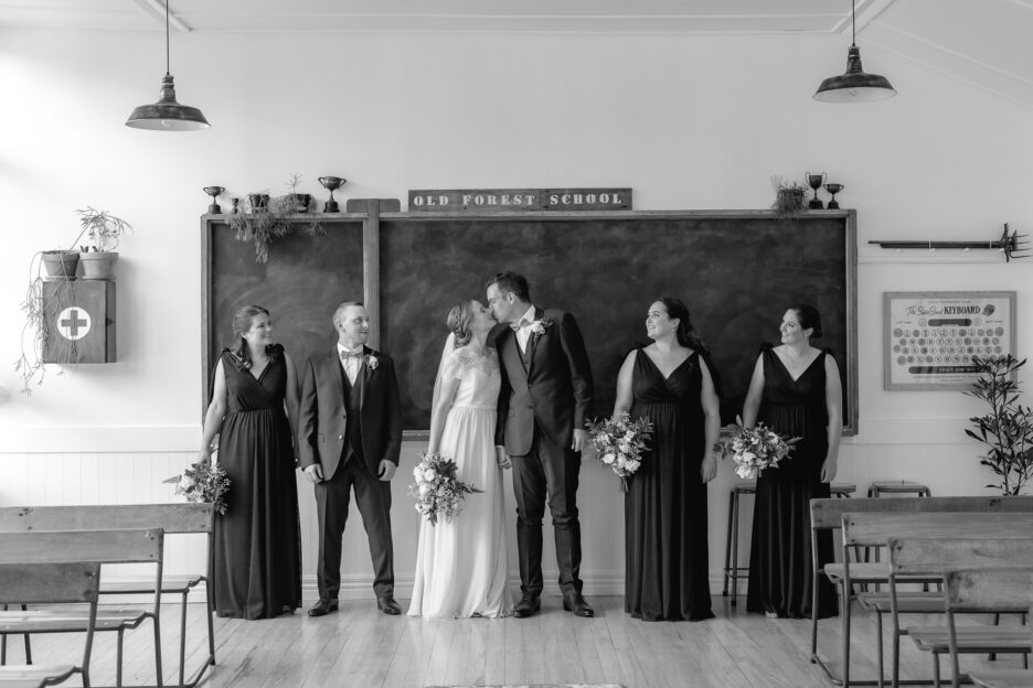Bride and groom kissing in school house Old Forest School