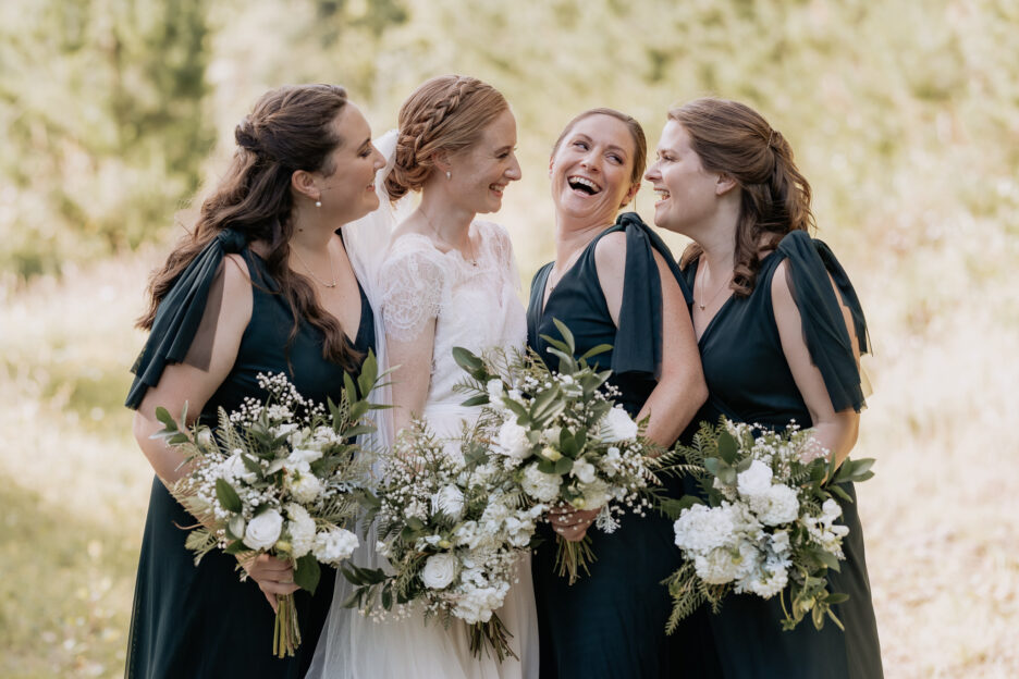 Happy relaxed bride with green bridesmaids in the forest at Old Forest School