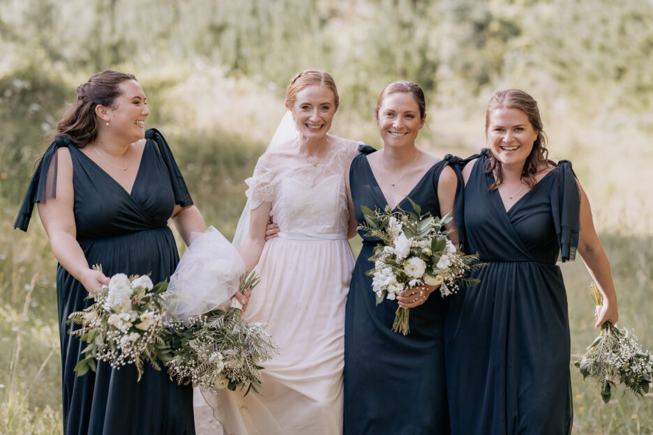 Relaxed happy bride with her green bridesmaids at Old Forest School
