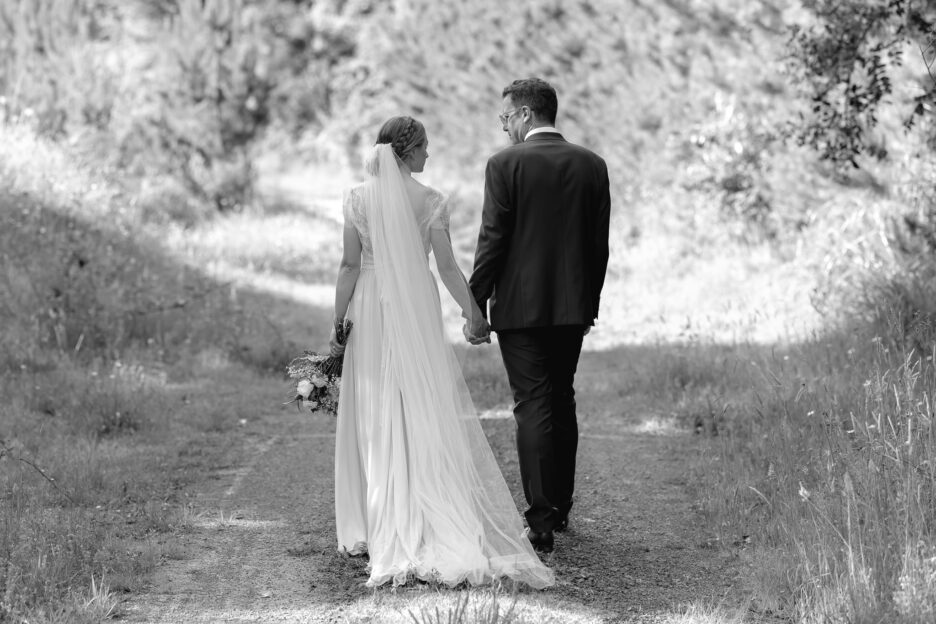 Wedding couple walking country lane in forest New Zealand