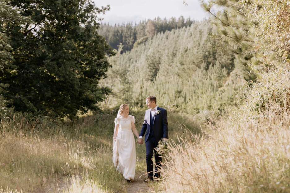 bride and groom walking country lane in the forest Te Puke wedding