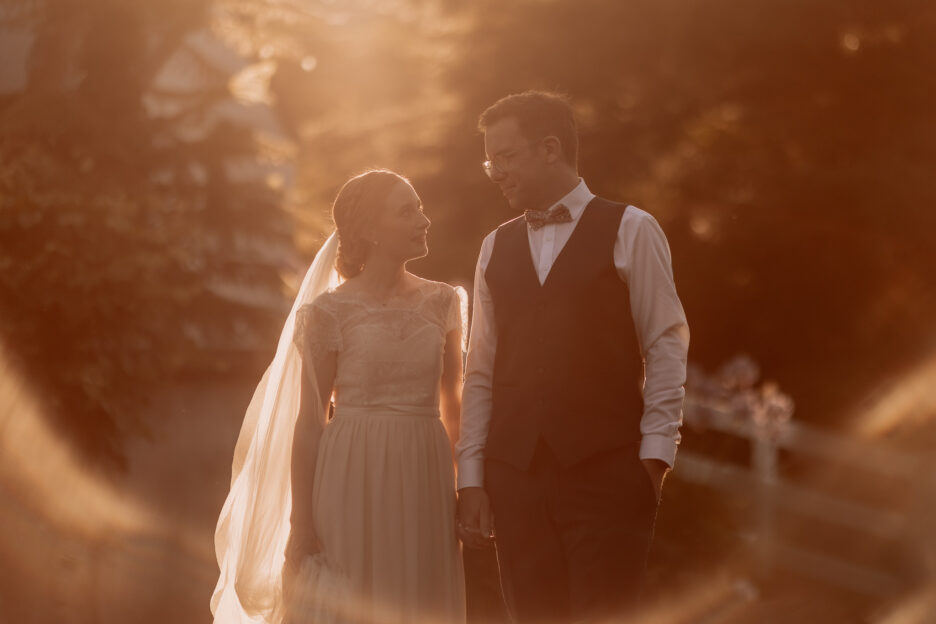 Wedding couple walking in sunlight at old forest School