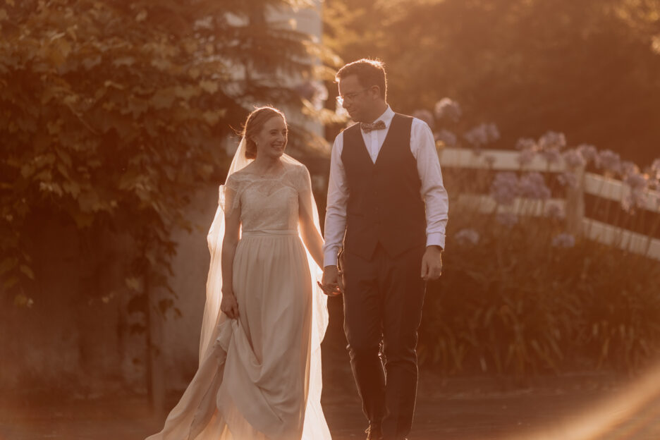 happy golden hours photos as couple walk in the country Te Puke New Zealand wedding