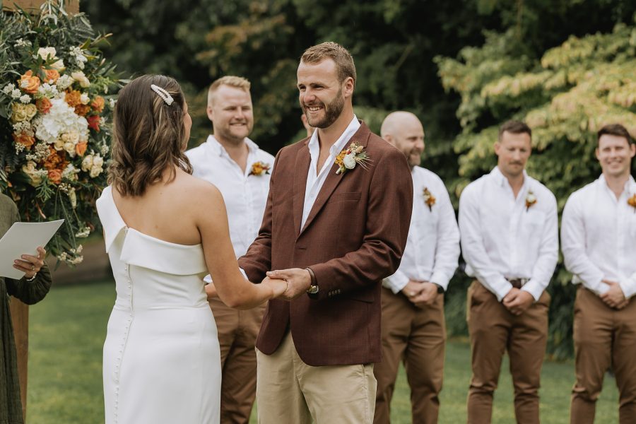 groom smiles at bride during ceremony