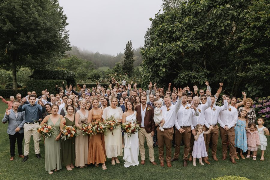 Group photo happy guests and wedding party waving at camera