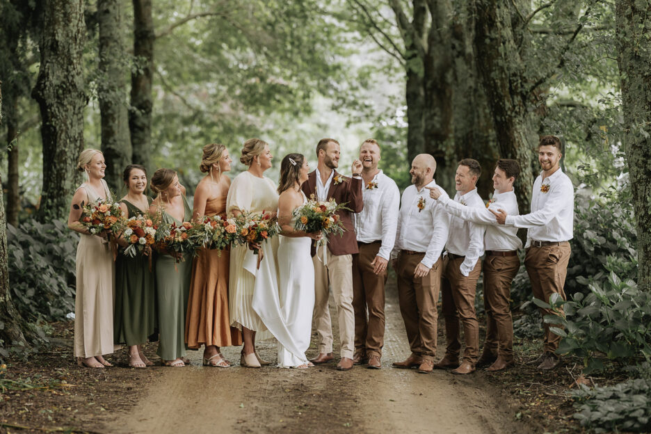 Bridal party laughing during wedding party photos at the Run driveway Whakatane