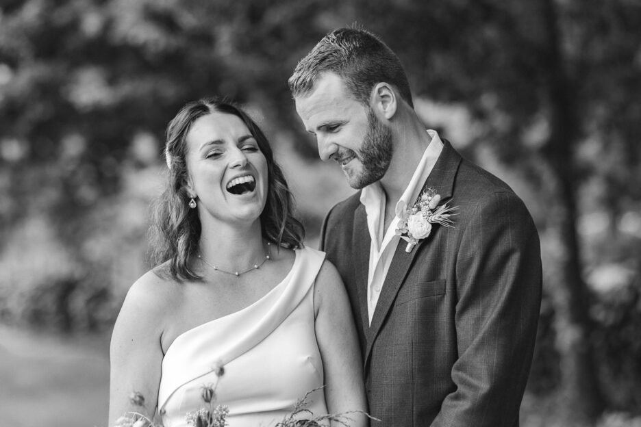 Bride laughing at groom in black and white photo