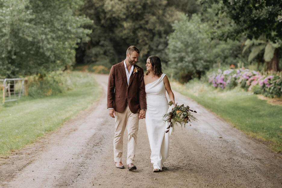 Couple road walking at the Run Whakatane wedding venue