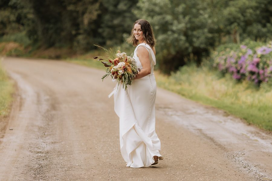 Natural photo of bride walking on country road at the Run Whakatane