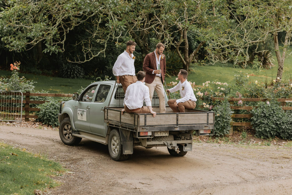 Groom with groomsmen on farm yute during wedding photos