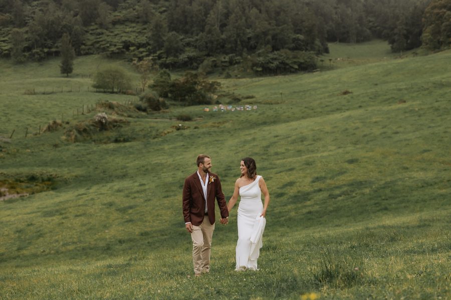 Wedding couple walking across field Whakatane the run venue