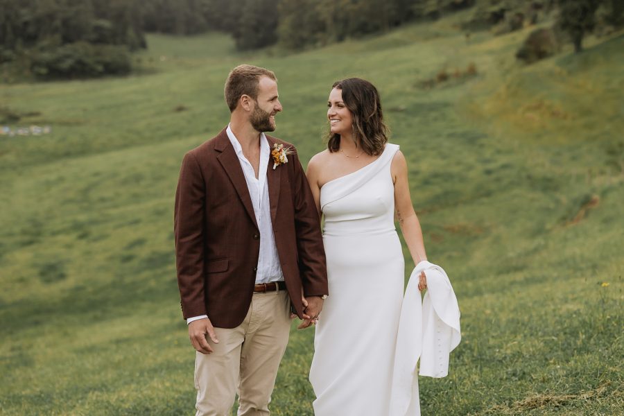 Wedding photos at the run Whakatane bride and groom walking smiling holding hands