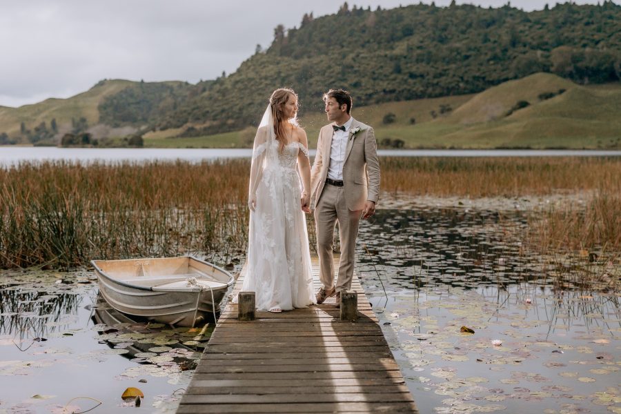 Longfords Lake Wedding couple walking on pier with row boat