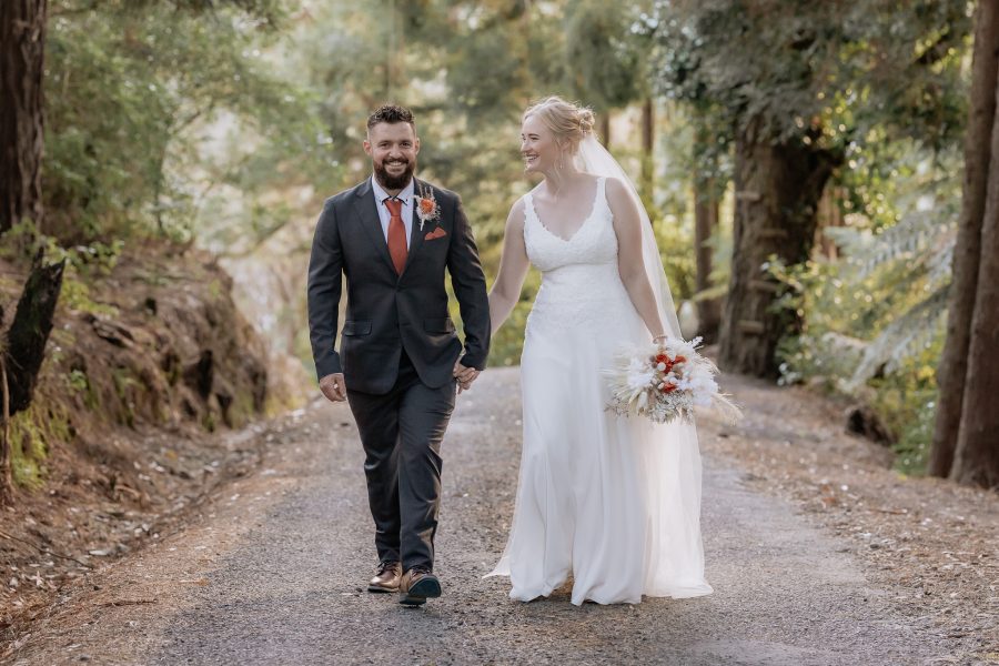 Groom walks looking at camera during photos