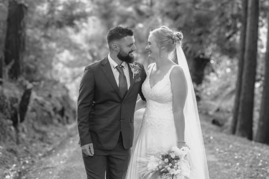 Bride and groom stop to look at each other during wedding photos at Falls retreat driveway