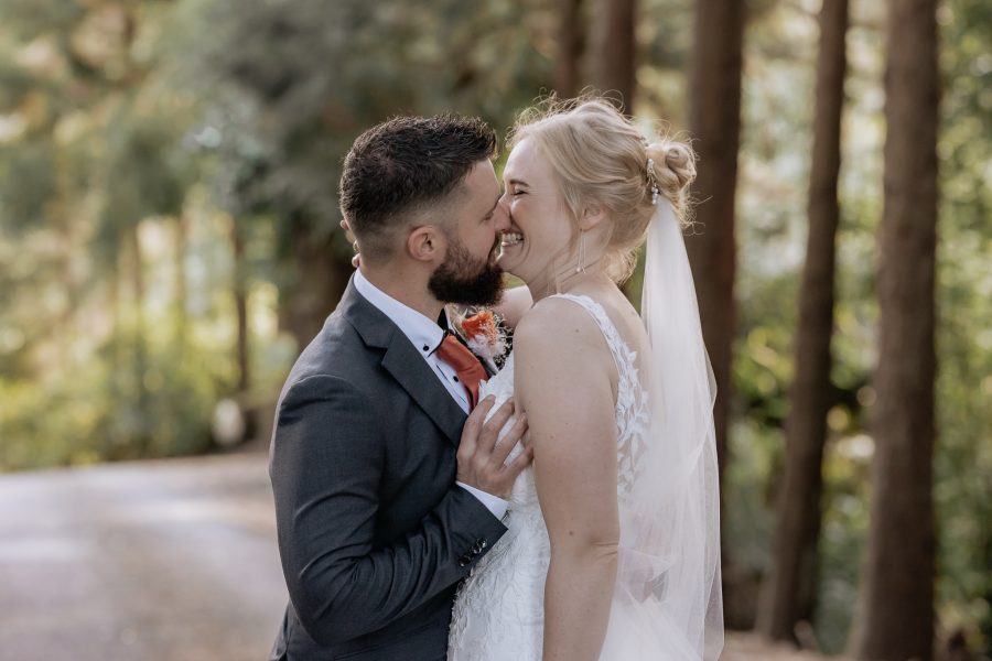 Groom laughingly grabs Bride during photos