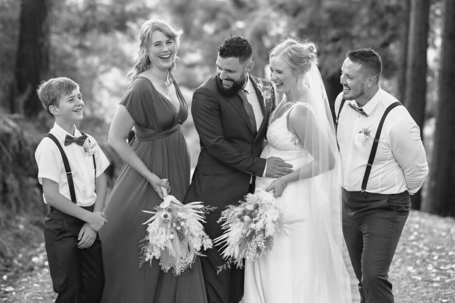 Wedding party laughing on driveway