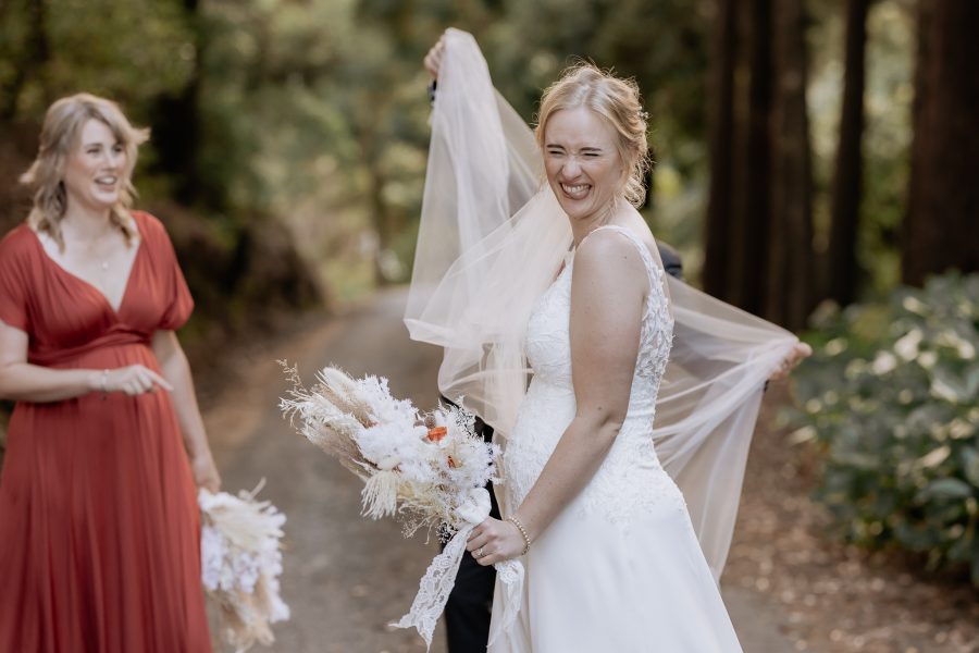 Bride winks as detangles her veil