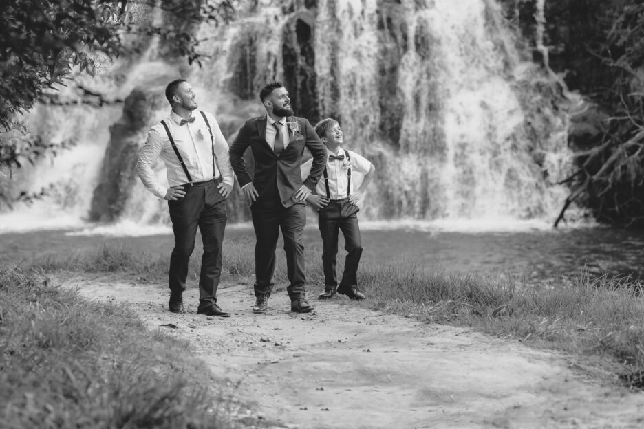 Groomsmen being silly at Owharoa Falls New Zealand during wedding photos