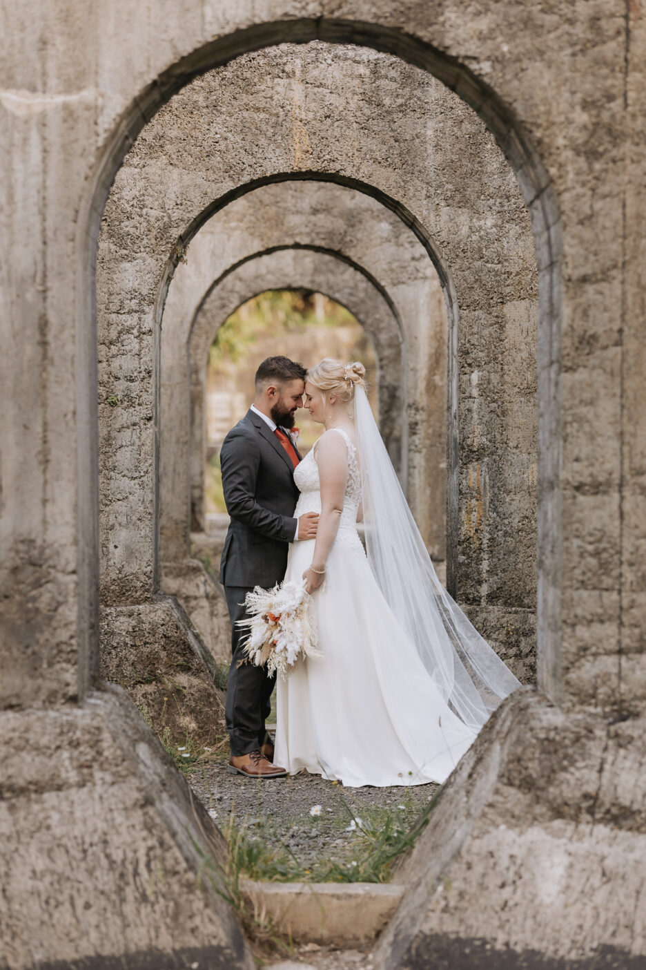 Image in arches of wedding couple at historic Victoria Battery Waihi New Zealand