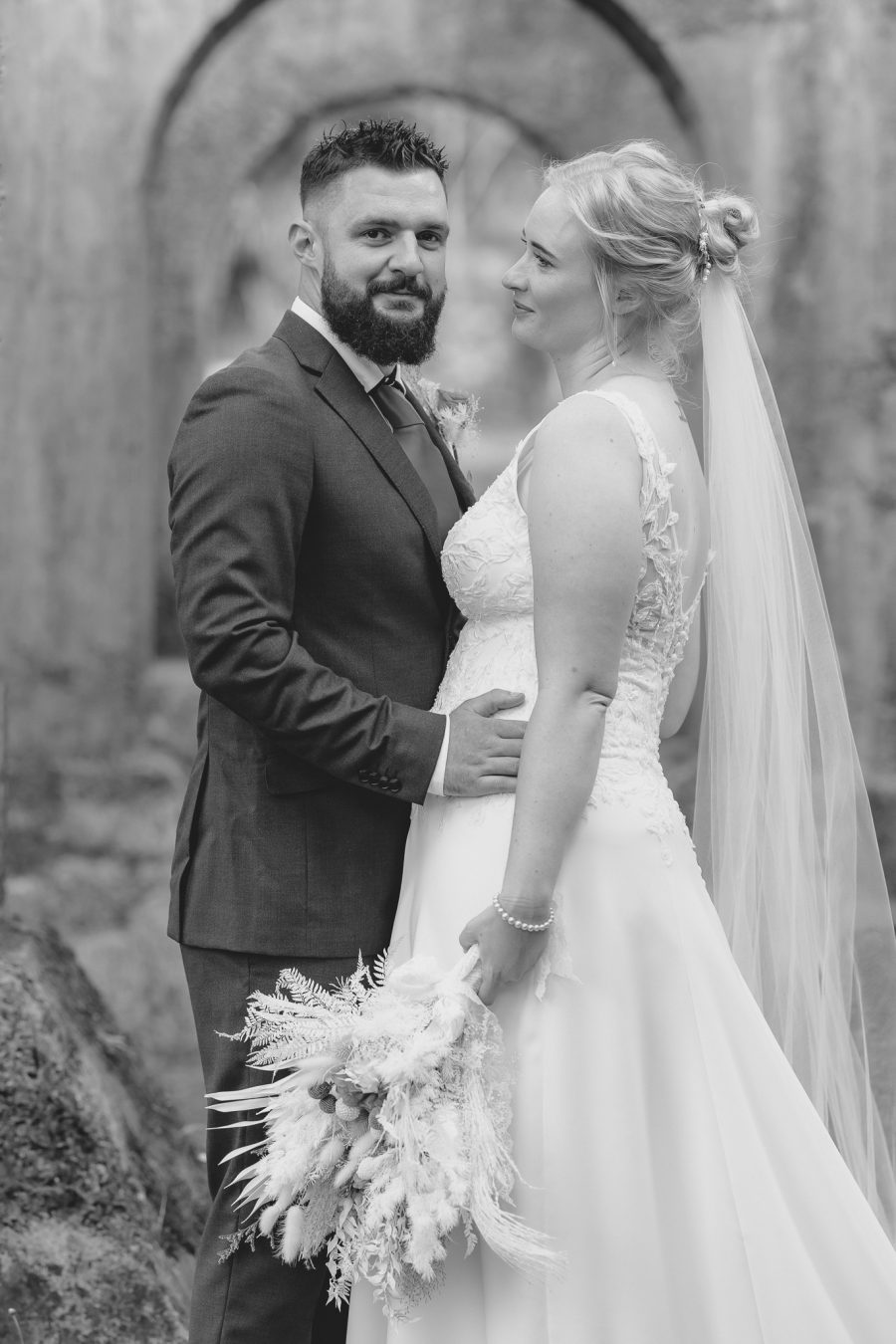 Bride looking at groom in historic ruins at Waihi