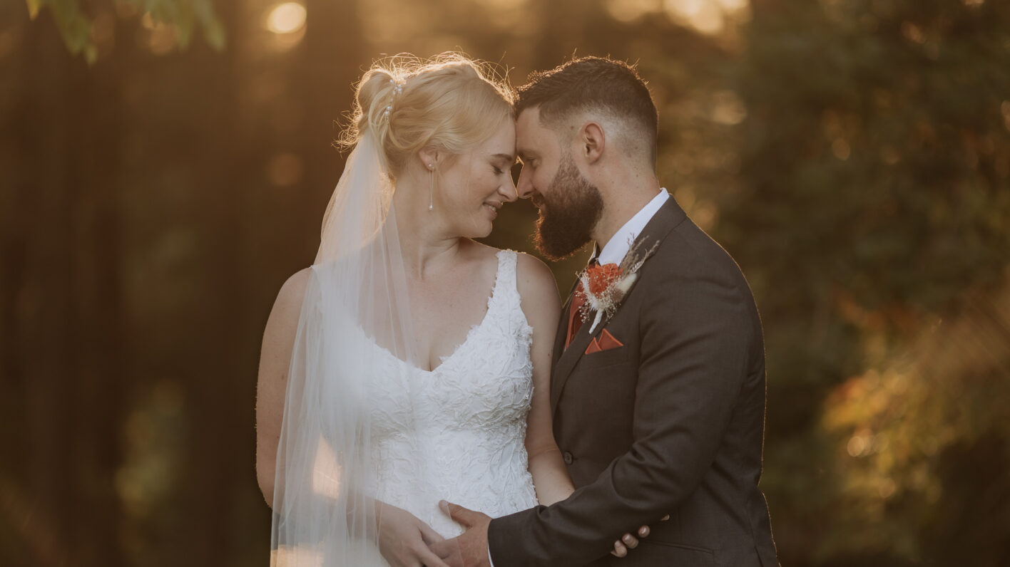 Bride and groom with sunlight coming through the trees