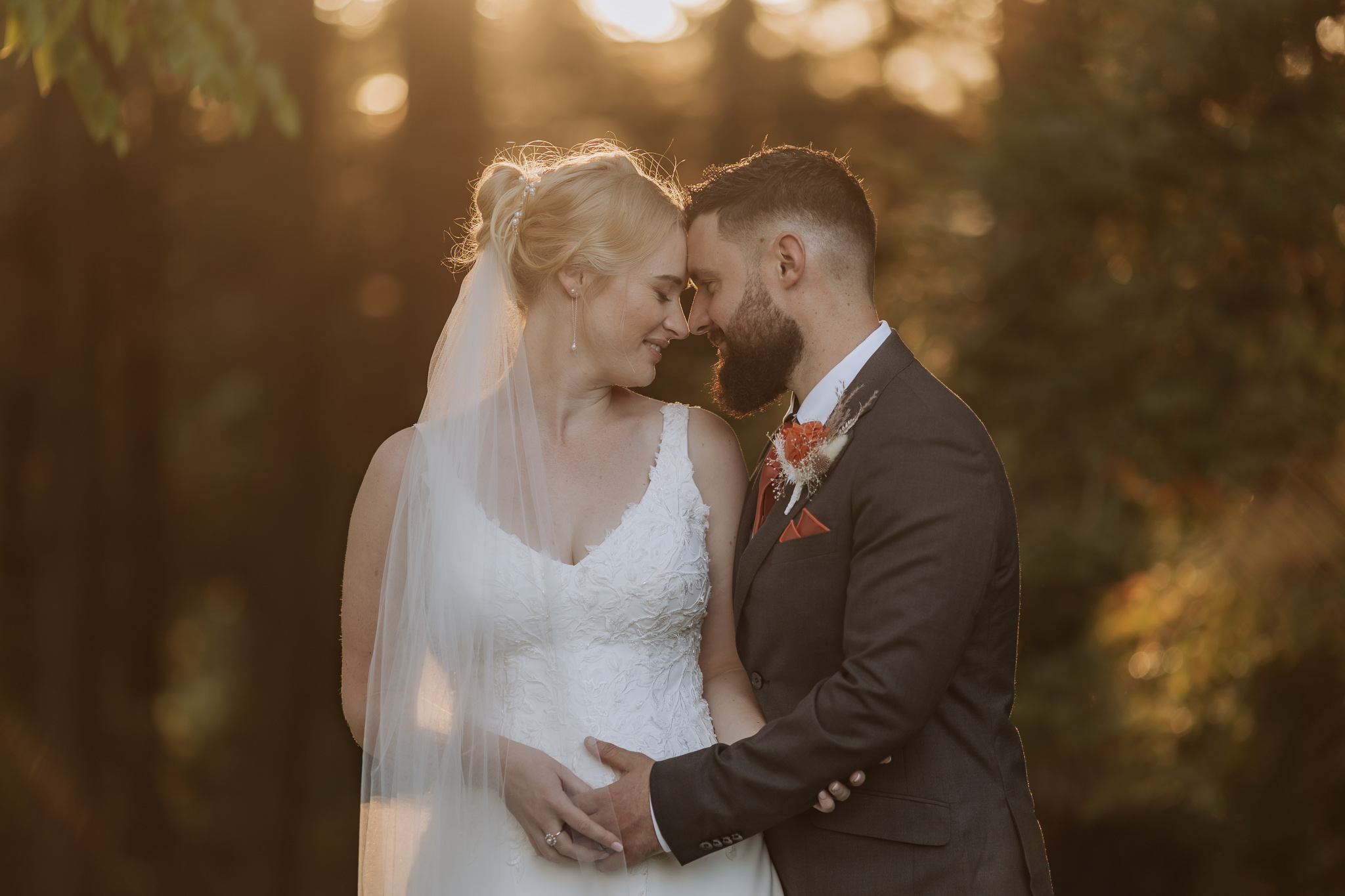 Bride and groom with sunlight coming through the trees