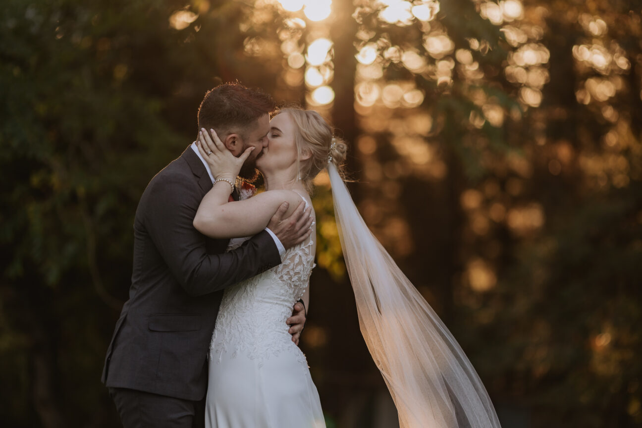Bridal couple kissing in golden light