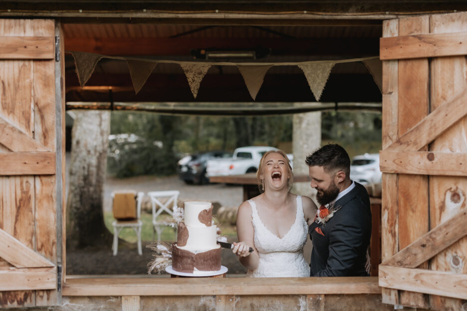 Bride laughing as cake cutting at Falls Retreat restaurant