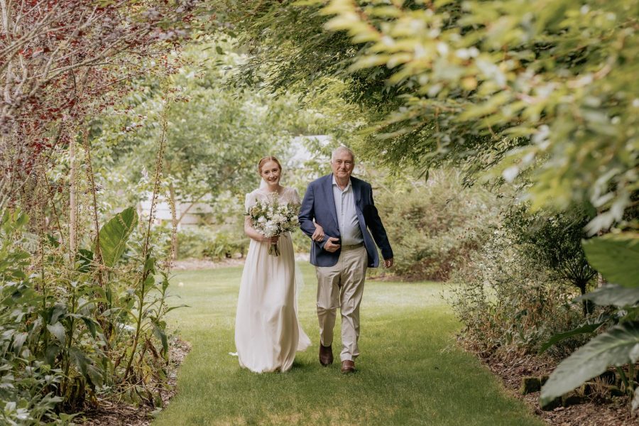 Bride walks down garden aisle with Father of the Bride arriving at Old Forest School Te Puke