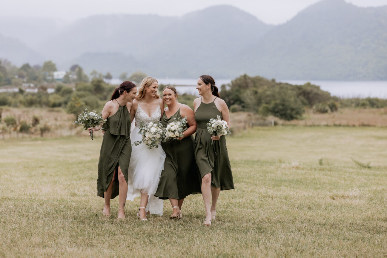 Laughing bride with bridesmaids in Taupe green having fun