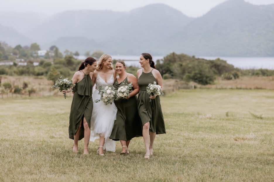 Laughing bride with bridesmaids in Taupe green having fun